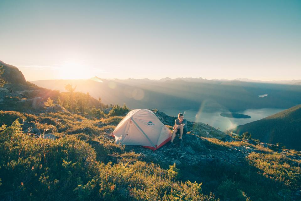 Camp at sunrise above an alpine lake